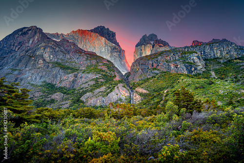 Magical colorful sunrise at major peaks, standing high towers teeth, and waterfall nearby surrounded by wet austral forests in Torres del Paine National Park, Patagonia, Chile, details photo