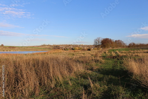 A grassy field with a body of water in the distance