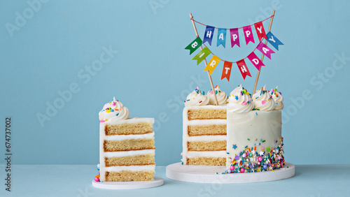 Birthday cake with slice removed and happy birthday cake topper