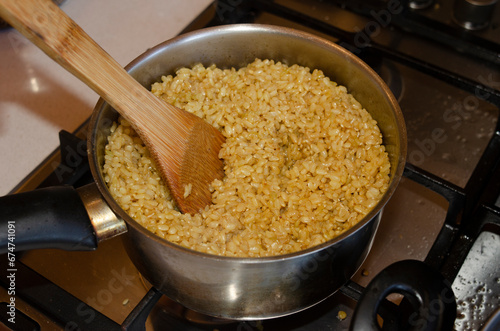 shamani brown rice in pot with wooden spoon
