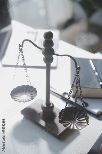 Business and lawyers discussing contract papers with brass scale on desk in office. Law, legal services, advice, justice and law concept picture with film grain effect