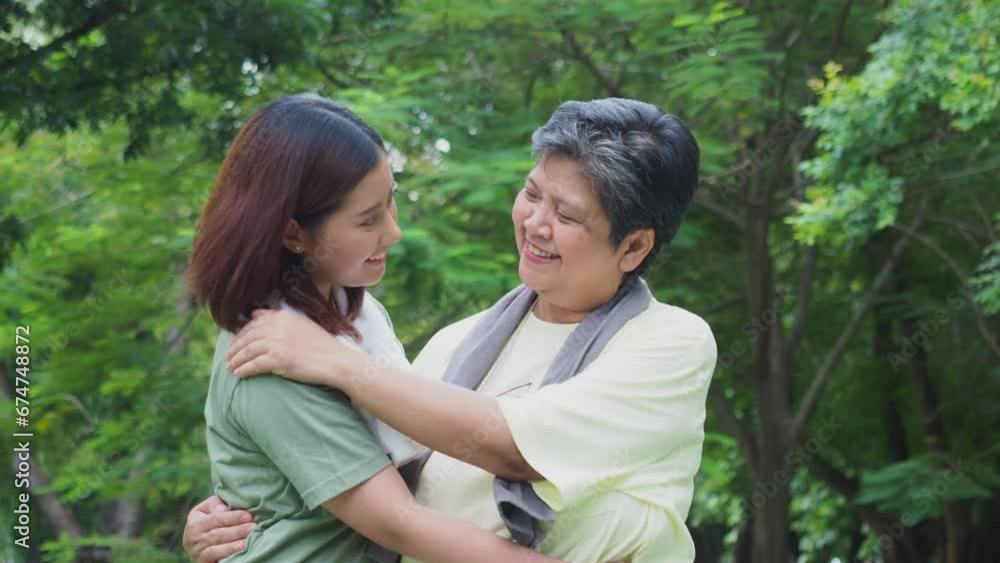 Elderly mother and daughter hugging each other while exercising in the park. Elderly mother and daughter hugging each other while exercising in the park.