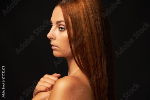 Hair care, ginger or woman thinking of beauty, skincare or results for glow, shine or collagen in studio. Black background, growth or serious model with cosmetics for healthy texture or textures