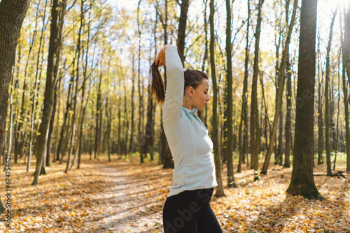 Beautiful girl doing fitness in nature on a sunny autumn forest. Body positive, sports for women, harmony, healthy lifestyle, self-love and wellness.