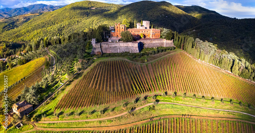 Italy, scenery of Tuscany. aerial drone view of beautiful medieval castle Castello di Brolio in Chianti region surrounded by golden autumn vineyards photo