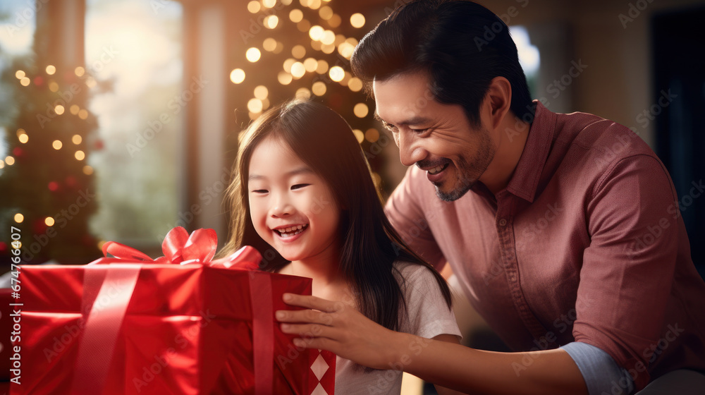 Asian father mother and daughter wrap gifts in the living room