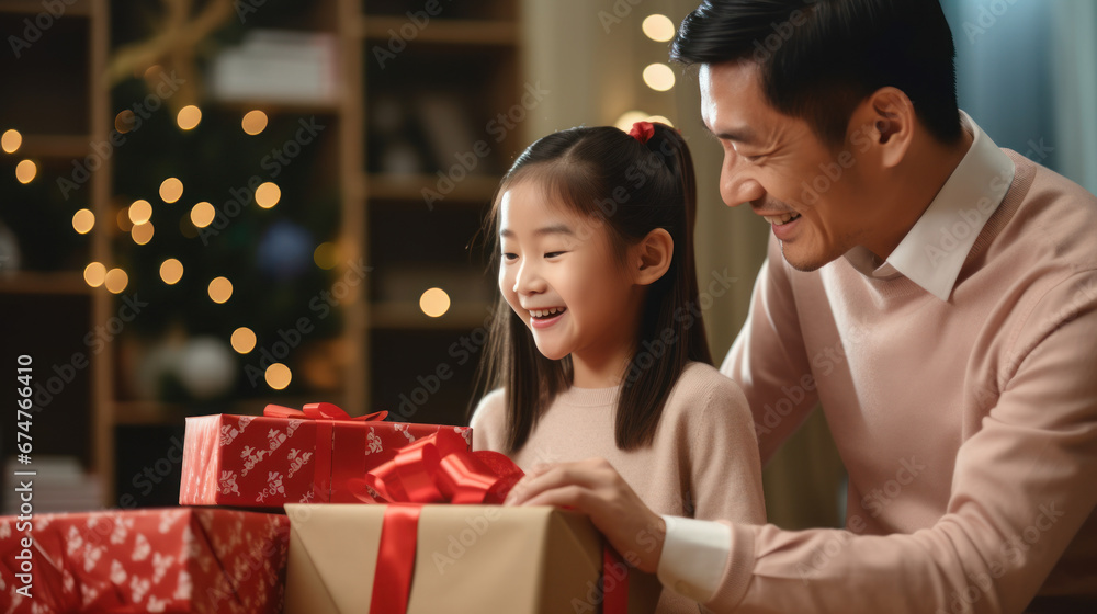 Asian father mother and daughter wrap gifts in the living room Asian father mother and daughter wrap gifts in the living room