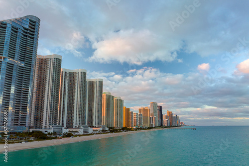 View from above of luxurious highrise hotels and condos on Atlantic ocean shore in Sunny Isles Beach city in the evening. American tourism infrastructure in southern Florida