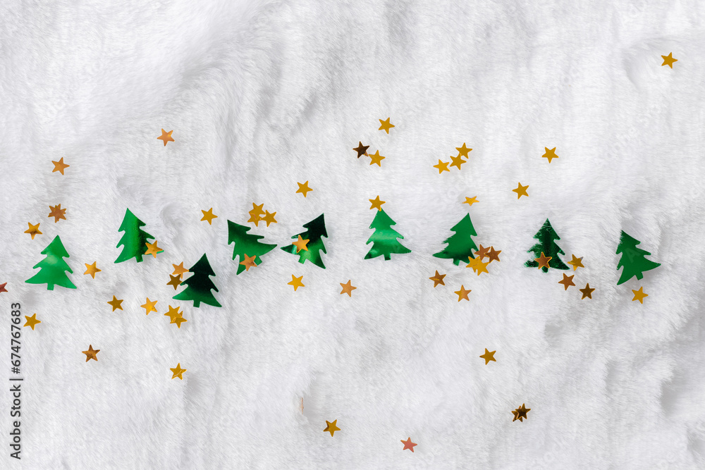 Φωτογραφία Merry Christmas and Happy New Year background with golden shiny yellow stars sequins and fir tree shape green color confetti on white fur as snow, copy space