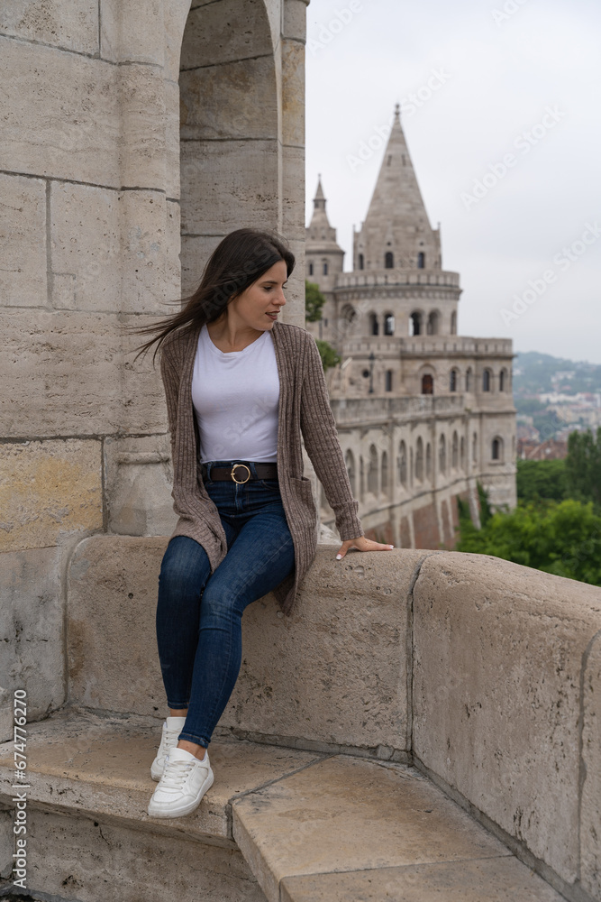 Young woman sitting looking to the side at the Fisherman's Bastion in Budapest