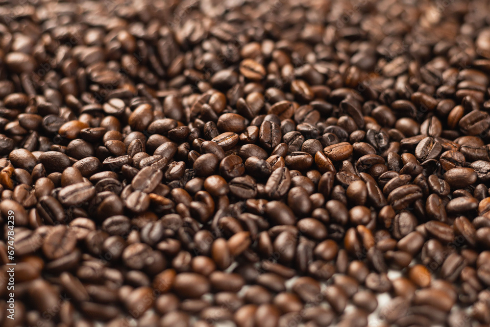 A pile of many freshly roasted and fragrant coffee beans can be used as a background or illustration. A pile of many freshly roasted and fragrant coffee beans can be used as a background or illustration.