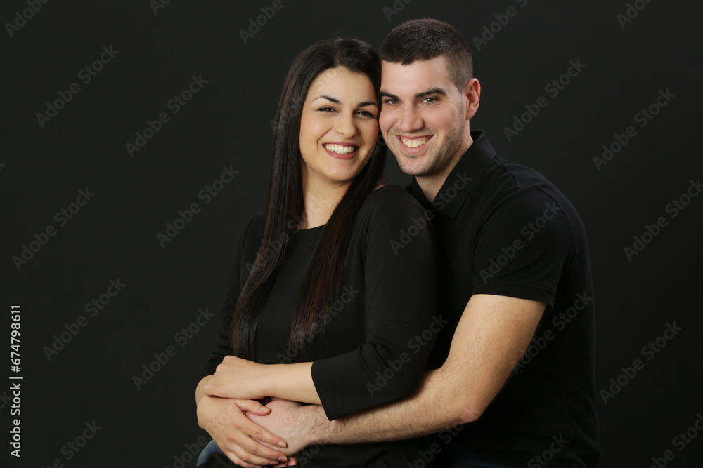 Studio portrait of young couple on the black background Studio portrait of young couple on the black background