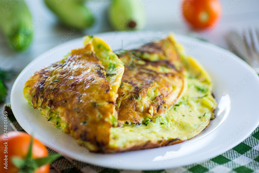 Fried omelet with zucchini, on a wooden table. Fried omelet with zucchini, on a wooden table.