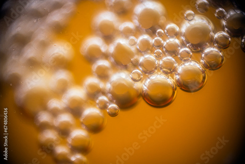 a lot of beer bubbles on the walls of the glass in macro 