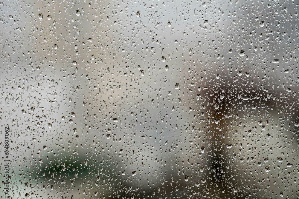 window glass with raindrops showing blurred city in the background window glass with raindrops showing blurred city in the background