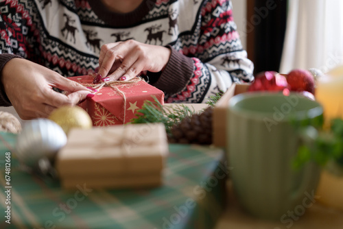 Woman preparing christmas gift box at home.