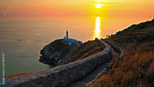 Panoramic view of South Stack Lighthouse at north-west coast of Holy Island, Anglesey, Wales. Lighthouse with steps and picturesque footbridge over the wild Atlantic ocean. photo
