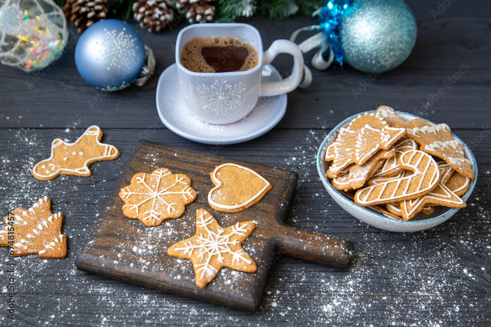 Traditional homemade gingerbread cookies and a cup of coffee on a dark wooden table. Christmas decor, holiday mood. Traditional homemade gingerbread cookies and a cup of coffee on a dark wooden table. Christmas decor, holiday mood.