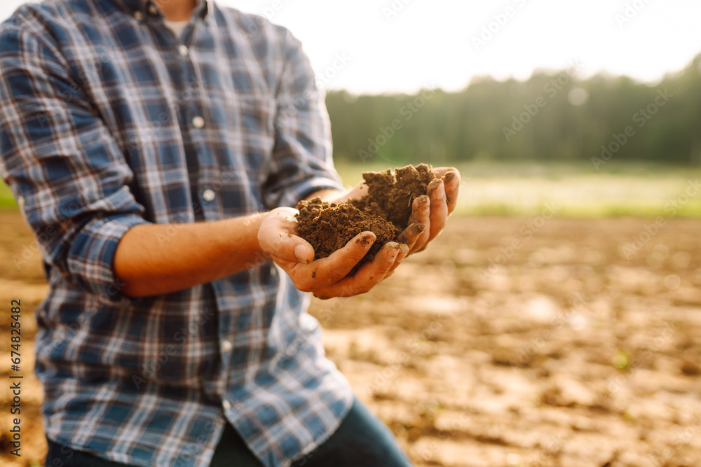 Farmer's hands take the soil from the field and check its quality. Experienced male hands hold the soil. Business, ecology concept. Farmer's hands take the soil from the field and check its quality. Experienced male hands hold the soil. Business, ecology concept.