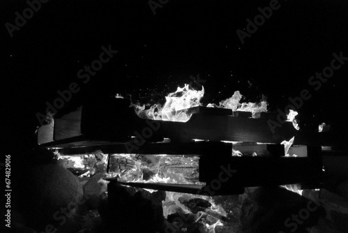 Bonfire on beach, burning pallets and drift wood, black and white photo