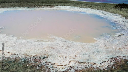 Subsidence funnels on salt marsh are filled with lakes of diverse colors. Red color caused by bacterias Dunaliella salina, Salinibacter ruber, white cloudy color due concentration of hydrogen sulfide photo