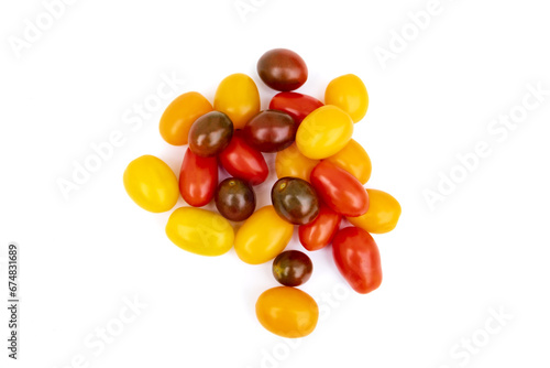 Different sorts of tomatoes isolated on white background. Fresh, ripe type of small and round cocktail tomatoes, of red, yellow and orange color. Solanum lycopersicum var. cerasiforme. 