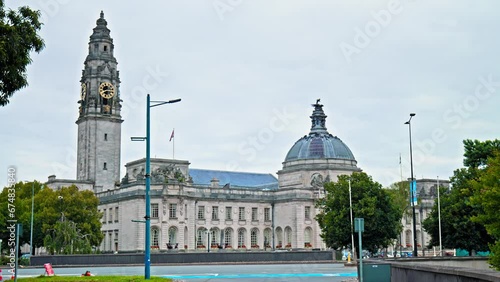 View of Cardiff City Hall municipal building with a clock tower and a Welsh dragon sculpture in Cardiff. The Edwardian baroque civic centre of local government in Wales.  photo