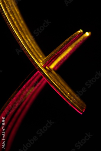 Horquillas de cuatro dientes de acero inoxidable para diversas costumbres alimentarias, con luz de color rojo y amarillo en forma de cruz, forman un diseño abstracto muy original con fondo negro