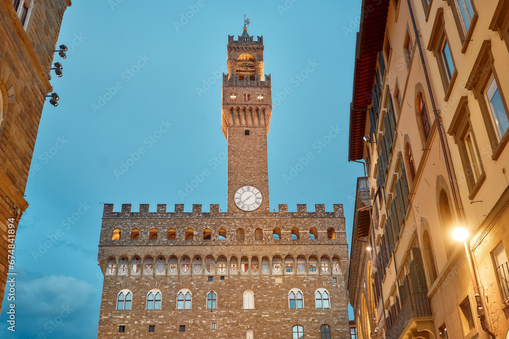 Fototapeta premium Palazzo Vecchio in Piazza della Signoria framed between two historic buildings in the evening in Florence