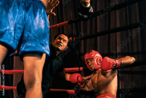 Boxing referee intervene, halting the fight to check fallen competitor. Intense and fierce boxing match with referee pauses the action for boxer fighter\'s safety. Impetus