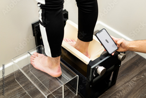 A professional podiatrist templates a patient using a 3D scanner in a physiotherapy clinic. Customized insoles. Use your mobile phone to see the recreation of the foot in three dimensions ©  Yistocking