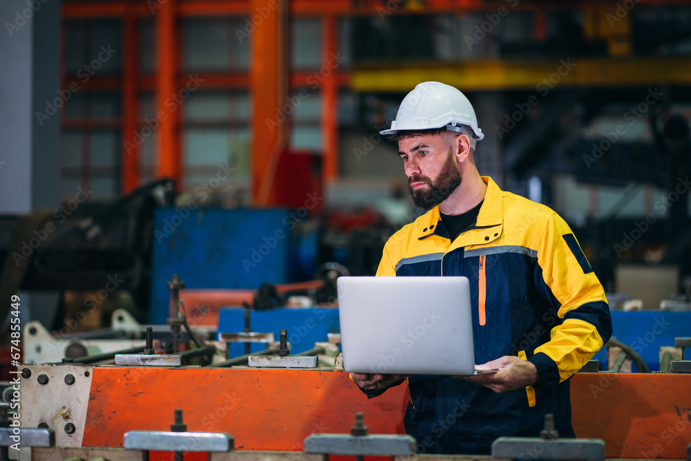 Industrial worker inspecting with labtop machine at factory machines. Technician working in the metal sheet company. Industrial worker inspecting with labtop machine at factory machines. Technician working in the metal sheet company.