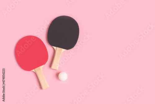Tennis rackets and white ball on a pink pastel background. Place for text.