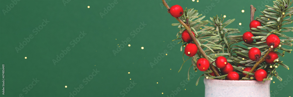 Banner with bouquet of nobilis fir and winterberry branches in front of green background. - obrazy, fototapety, plakaty 