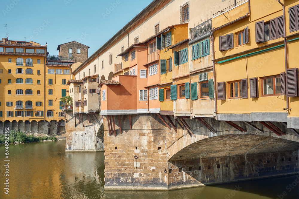 Close-up of the old bridge seen from the right side, jewelers' shops in the foreground and the Arno river in Florence