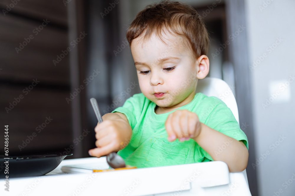 The Curious Toddler in the High Chair. A little boy that is sitting in a high chair The Curious Toddler in the High Chair. A little boy that is sitting in a high chair