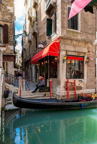 Narrow canal with gondola in Venice, Italy. Architecture and landmark of Venice. Cozy cityscape of Venice. photo
