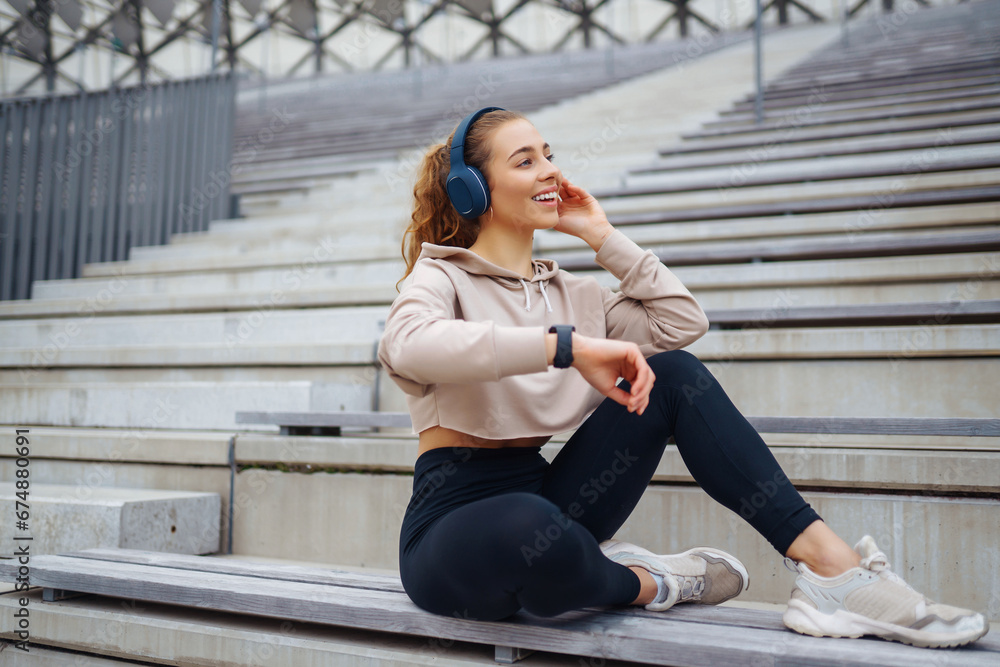 Attractive young woman in sportswear stretches outdoors. An athlete performs exercises on the sports ground. Health concept. Active lifestyle. Attractive young woman in sportswear stretches outdoors. An athlete performs exercises on the sports ground. Health concept. Active lifestyle.