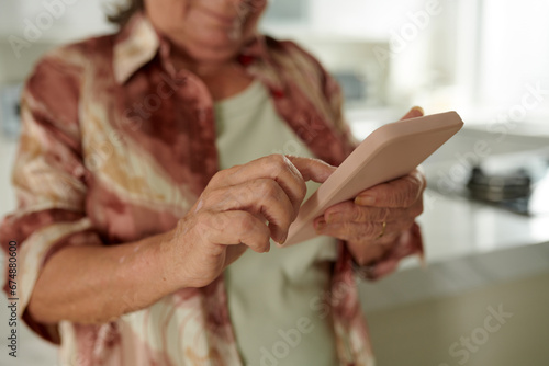 Closeup image of senior woman checking notifications on smartphone