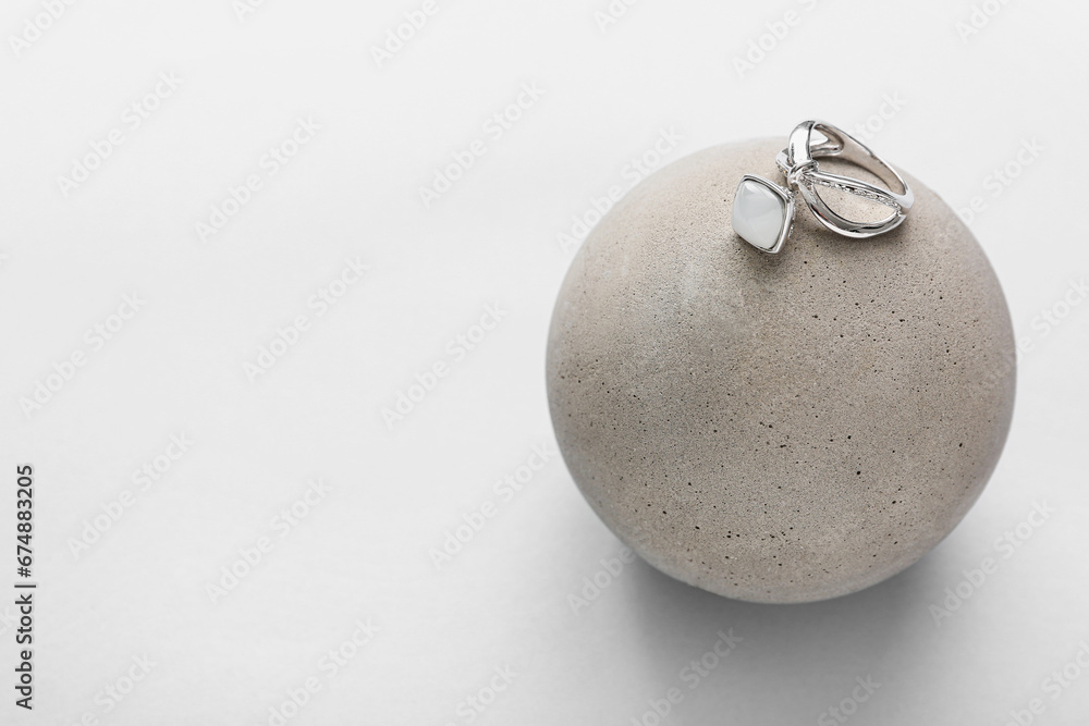 Showcase pedestal with silver ring on light background Showcase pedestal with silver ring on light background
