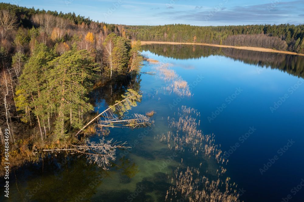 Beautiful landscape of lake Bolduk in the morning, Vitebskay region. Landscape of magic lake Bolduk in sunny autumn day. The sky is reflacted in th water of lake.