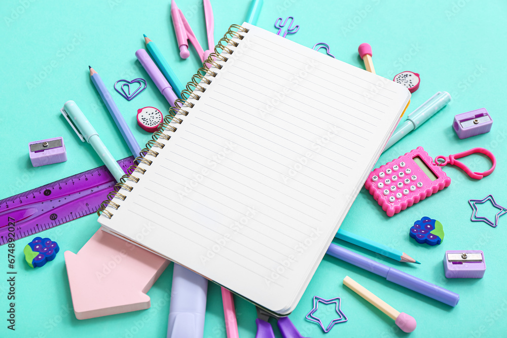 Notebook with different stationery supplies on blue background Notebook with different stationery supplies on blue background