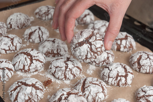 A woman's hand holds a chocolate cookie.Homemade baking close-up.