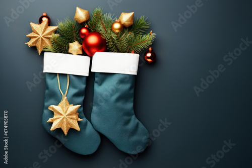 Flat lay with stockings filled with gifts and branches of Christmas tree placed on dark blue background with copy space. Three Kings Day, Epiphany day, Christmas.