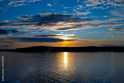 Fototapeta Naklejka Na Ścianę i Meble -  Sun setting over an island.