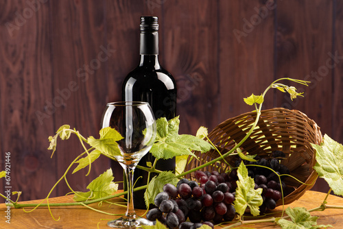 Grapes and wine, basket with beautiful grapes and bottle of red wine, on rustic wood, selective focus.