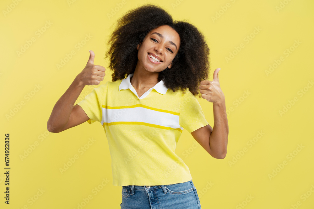 Excited smiling African American woman showing thumbs up, looking at camera Excited smiling African American woman showing thumbs up, looking at camera