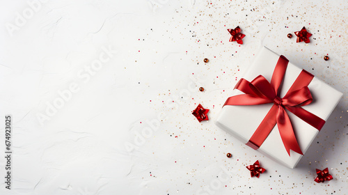 A white box with a red gift bow for festivity. Gift box in touch of warmth and celebration for end of year festivities.