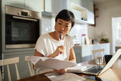 Concerned woman doing home financials in the kitchen photo