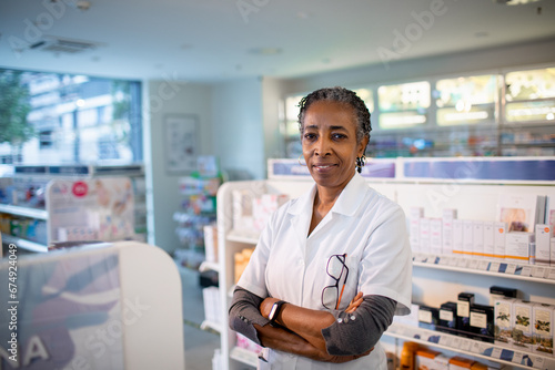 Senior female pharmacist looking at camera in pharmacy photo